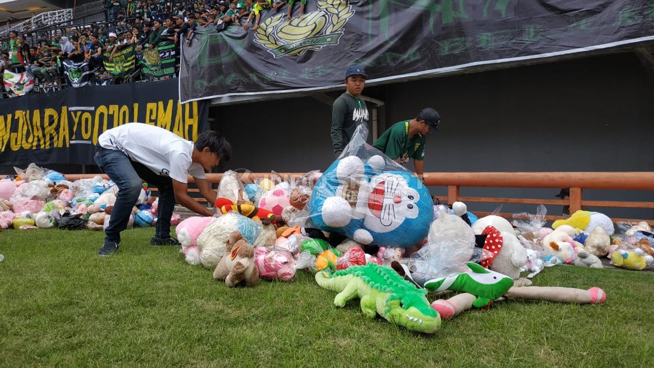 Hujan Boneka di laga Persebaya vs Tira Persikabo sebagai bentuk solidaritas untuk anak-anak penderita kanker. Copyright: © Fitra Herdian/Indosport.com