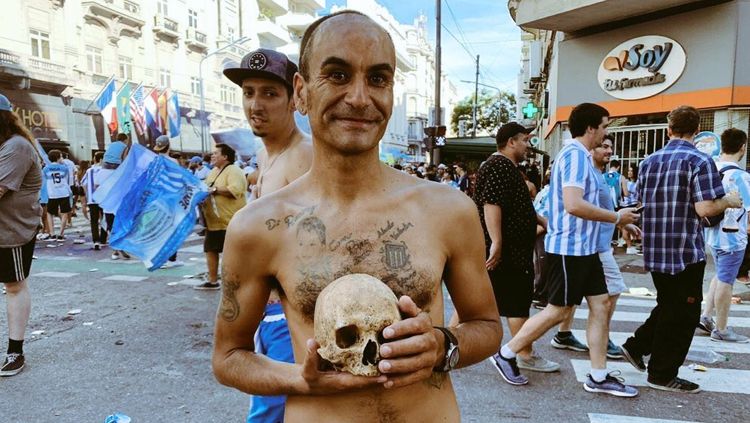 Salah seorang fans sepak bola membawa tengkorak kepala manusia. Copyright: © Twitter@FutbolEsquema