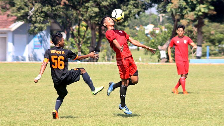 Salah satu pemain Persis Solo (merah) berebut bola dengan pemain PS UNS dalam uji coba di Lapangan AURI Lanud Adi Soemarmo, Karanganyar, Sabtu (06/04/19). Copyright: &copy; Indosport/Ronald Seger Prabowo