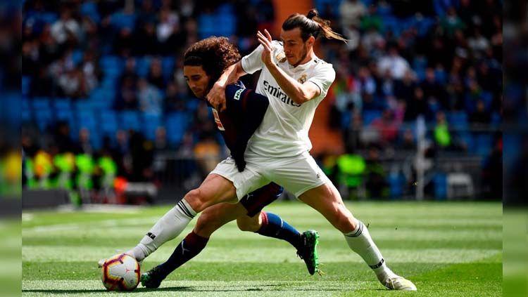 Gareth Bale dihadang pemain lawan pada pertandingan Real Madrid vs Eibar di LaLiga Spanyol, Sabtu (06/04/19). Copyright: © Twitter/@OptaJose