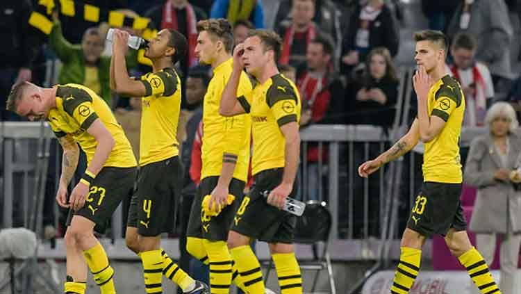 Para Pemain Borussia Dortmund tertunduk lesu saat mereka dilibas oleh rival, Bayern Munchen. Copyright: © GUENTER SCHIFFMANN/AFP/Getty Images