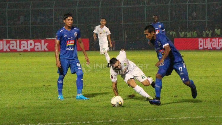 Damian Lizio (tengah, putih) bersusah payah mencoba merebut bola dari kaki pemain Arema FC (Fitra Herdian/INDOSPORT) Copyright: © Fitra Herdian/INDOSPORT