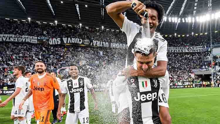 Juan Cuadrado meluapkan kegembiraannya ke Cristiano Ronaldo usai Juventus memastikan diri menjadi juara Serie A Italia 2018-19. Copyright: © Daniele Badolato - Juventus FC / GETTY IMAGES