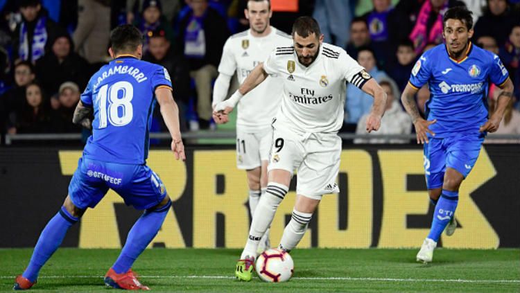 Benzema tengah berupaya melawati hadangan pemain Getafe, Jumat (26/04/19). Copyright: © Indosport