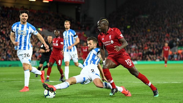 Sadi Mane (kanan) berusaha melewati hadangan para pemain Huddersfield di laga Liverpool vs Huddersfield, Sabtu (27/04/19). Michael Regan/Getty Images. Copyright: © Michael Regan/Getty Images