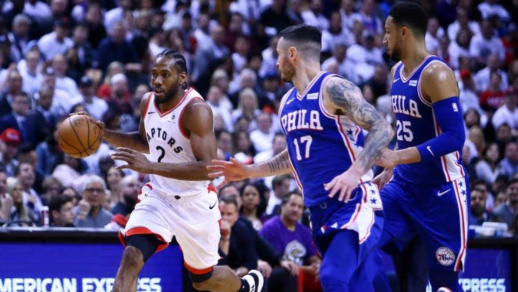 Bintang basket Toronto Raptors, Kyle Lowry dihadang dua pemain Philadelpia 76ers dalam NBA Playoffs 2019. Copyright: © Vaughn Ridley/Getty Images