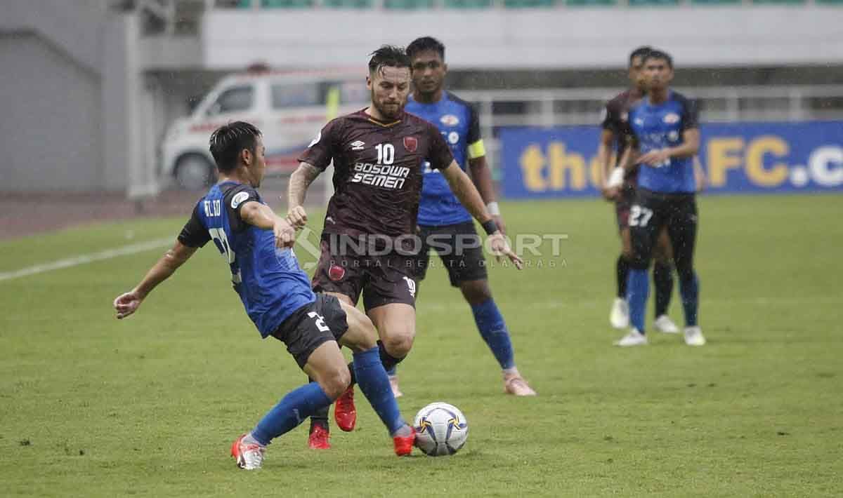 Marc Klok berusaha mengambil bola dari salah satu pemain Home United. Herry Ibrahim/INDOSPORT Copyright: © Herry Ibrahim/INDOSPORT