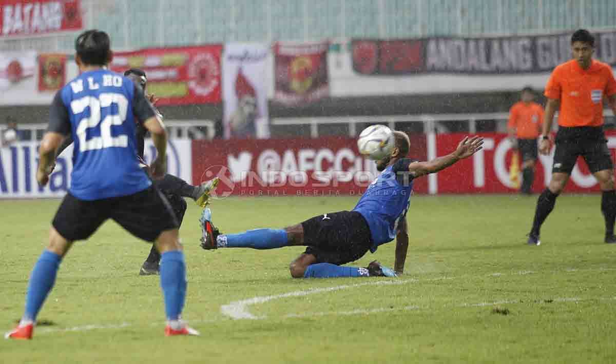 Salah satu pemain Home United menahan tendangan dari Guy Junior. Herry Ibrahim/INDOSPORT Copyright: © Herry Ibrahim/INDOSPORT