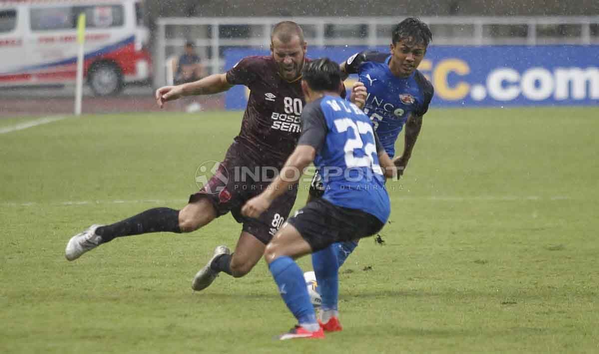 Wiljan Pluim saat akan mengeksekusi bola dari serangan dua pemain Home United. Herry Ibrahim/INDOSPORT Copyright: © Herry Ibrahim/INDOSPORT