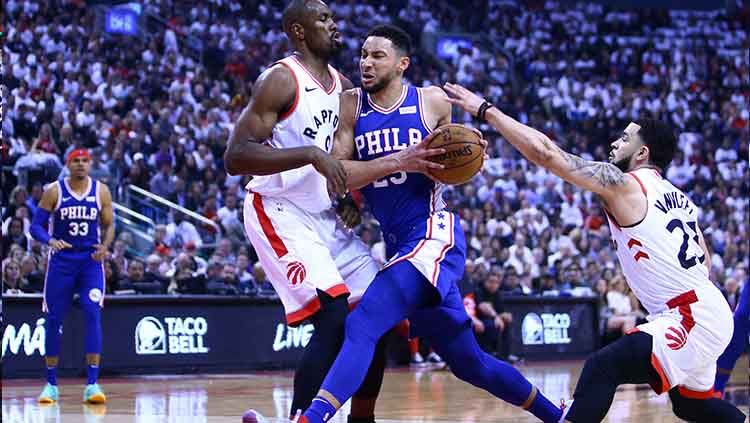 Bintang tim basket Philadelphia 76ers, Ben Simmons mencoba mendribel bola melewati hadangan pemain Toronto Raptors. Copyright: © Vaughn Ridley/Getty Images