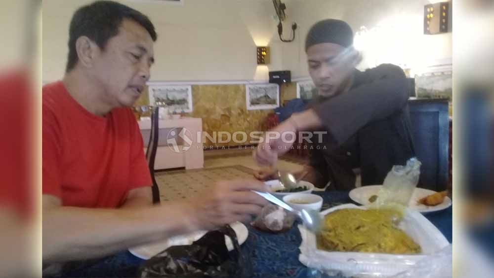 Jandia Eka Putra saat mencoba memakan kepala ikan kakap bersama pelatih Jafri Sastra. Foto: Ronald Seger Prabowo/INDOSPORT Copyright: © Ronald Seger Prabowo/INDOSPORT