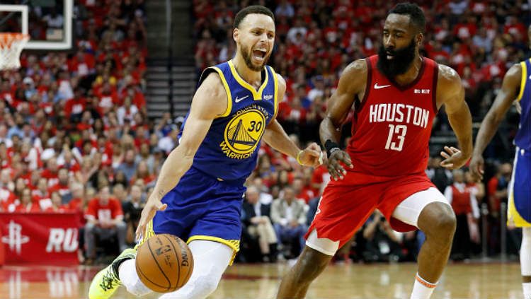 Bintang Golden State Warriors, Stephen Curry, berusaha melewati hadangan pemain Houston Rockets, James Harden. Copyright: © Tim Warner/Getty Images