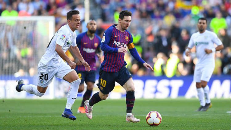 Lionel Messi saat membawa bola dan berusaha direbut oleh para pemain Getafe. Copyright: © Alex Caparros/Getty Images