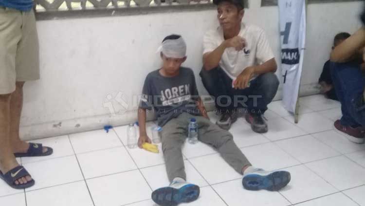 Salah satu bocah jadi korban pelemparan aksi suporter PSS Sleman vs Arema FC. Copyright: © Ronald Seger Prabowo/INDOSPORT