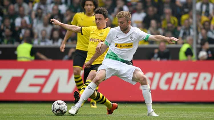 Christoph Kramer berusaha mengambil bola dari Thomas Delaney pada laga Bundesliga Jerman. INA FASSBENDER/AFP/Getty Images Copyright: © INA FASSBENDER/AFP/Getty Images