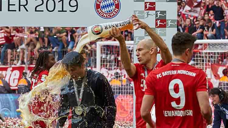Arjen Robben memandikan pelatihnya di Bayern Munchen, Niko Kovac setelah timnya memastikan diri menjadi juara Bundesliga Jerman 2018/19. Copyright: © TF-Images/GettyImages