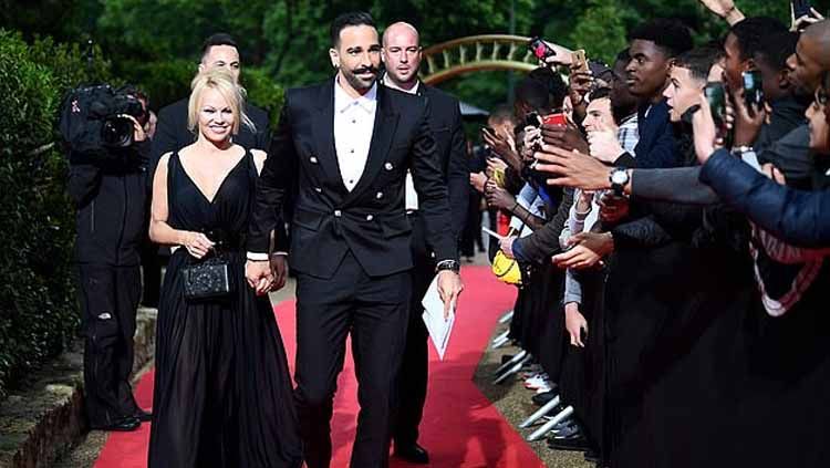 Bintang film Pamela Anderson bersama kekasihnya yang memperkuat Marseille, Adil Rami Copyright: © AFP/Getty Images