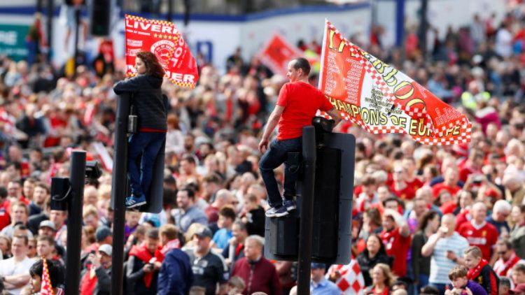 Suporter Liverpool menaiki lampu lalu lintas saat pawai juara Liga Champions, Minggu (02/06/19). Copyright: © Reuters