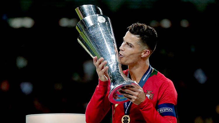 Pemain megabintang sekaligus kapten Timnas Portugal, Cristiano Ronaldo saat mencium trofi UEFA Nations League Copyright: © Socrates Images/GettyImages