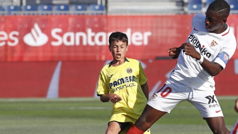 Pemain Sevilla U-12 (kanan) terlihat lebih besar dibandingkan lawannya. Copyright: © Sportbible