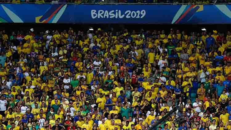 Suporter timnas Brasil sebagai tuan rumah tampak antusias dalam laga Copa America 2019 fase grup di Arena Fonte Nova, Rabu (19/06/19). Copyright: © Felipe Oliveira/Getty Images
