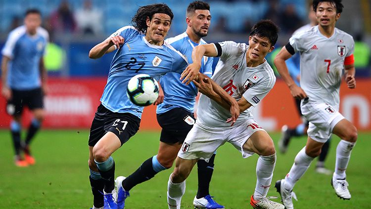 Edinson Cavani dan Takehiro Tomiyasu  di laga Uruguay vs Jepang pada turnamen Copa America 2019, Jumat (21/06/19) Copyright: © Chris Brunskill/Fantasista/Getty Images