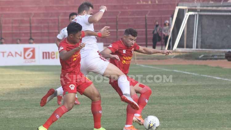 Salah satu pemain Bali United memaksa untuk merebut bola dari dua pemain Kalteng. Copyright: © Ronald Seger Prabowo/INDOSPORT