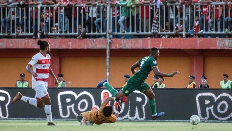 Striker Amido Balde dihalau kiper Muhammad Ridho pada laga Madura United vs Persebaya Surabaya di Kratingdaeng Piala Indonesia 2018/2019, Kamis (27/06/19). Copyright: © persebaya.id