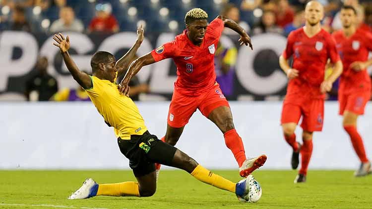 Pemain Amerika Serikat, Gyasi Zardes, menahan Je-Vaughn Watson pada laga semifinal Gold Cup di Nissan Stadium (03/07/19). Copyright: © John Dorton/isiphotos.com/Getty Images