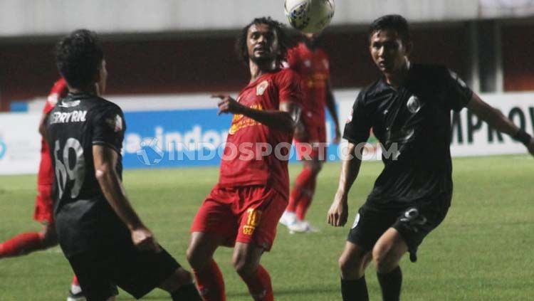 Hedipo Gustavo (tengah) dijaga dua pemain dalam laga pekan ketujuh Liga 1 2019 (Minggu, 07/07/2019). Copyright: © Ronald Seger Prabowo/INDOSPORT