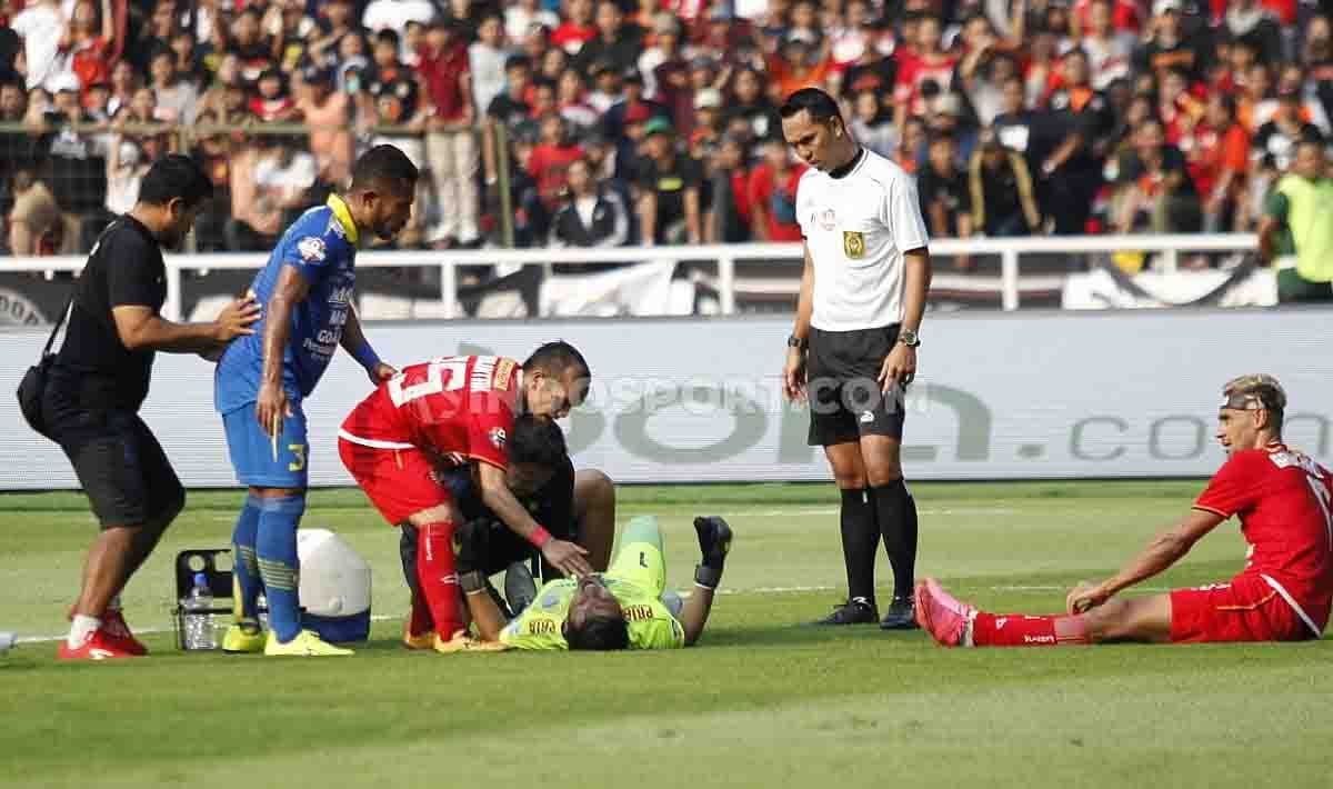 Kiper Persib, Deden Natshir (tengah bawah) mengalami cedera usai berbenturan dengan striker Persija Bruno Matos, 10 Juli 2019 lalu. Copyright: © Herry Ibrahim/INDOSPORT