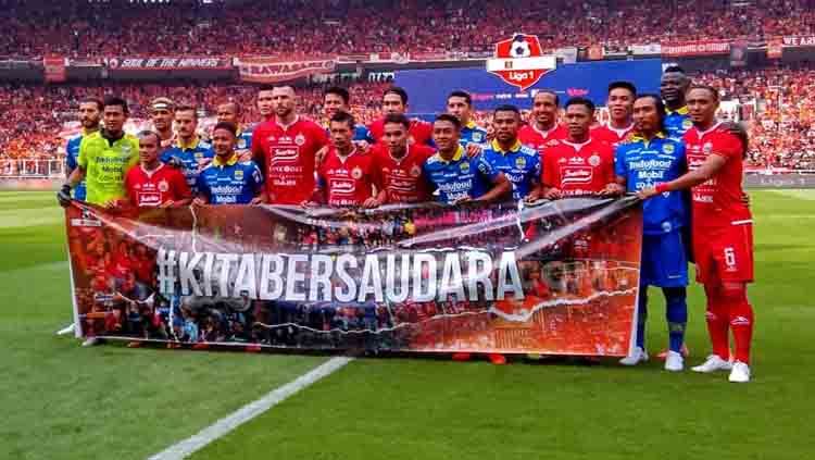 Skuat Persija Jakarta vs Persib Bandung dengan membentangkan spanduk #KitaBersaudara di laga Liga 1 2019 lalu. Copyright: © Arif Rahman/INDOSPORT