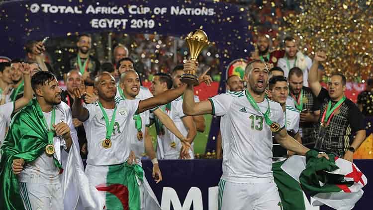 Para pemain timnas Aljazair merayakan kemenangan membawa trofi Piala Afrika 2019 di Cairo Stadium, (20/07/19). Oliver Weiken/picture alliance via Getty Images Copyright: © Oliver Weiken/picture alliance via Getty Images