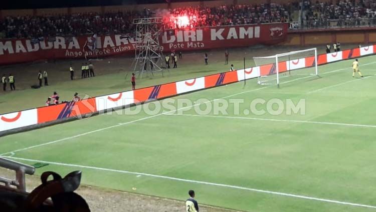 Suporter Madura United menyalakan flare sehingga berbuah ancaman sanksi komdis Copyright: © Ian Setiawan/INDOSPORT