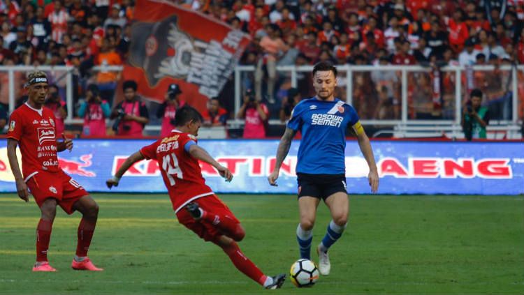 Gelandang PSM Makassar, Marc Klok (biru), mencoba merebut bola dari bek sayap Persija Jakarta, Ismed Sofyan (oranye). Copyright: © Official PSM Makassar