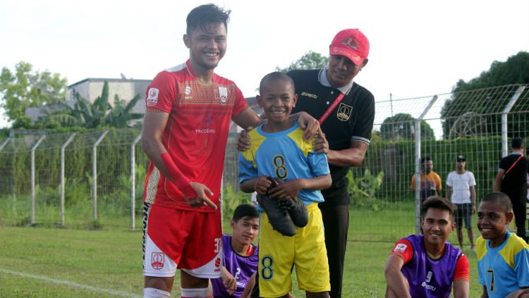 Gelandang Persis Solo, Tegar Hening Pangestu memberikan sepasang sepatu kepada salah satu bocah usai laga melawan PSBS Biak di Stadion Cendrawasih, Kamis (08/08/19). Copyright: © Media Persis Solo