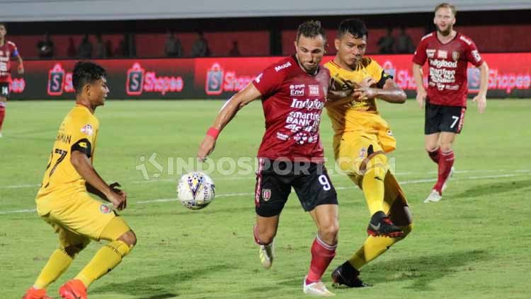 Dua pemain Semen Padang menghalau Spasojevic untuk merebut bola. Copyright: © Nofik Lukman Hakim/INDOSPORT