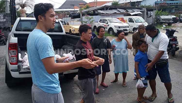 Penggawa Bali United, Gunawan Dwi Cahyo dan Dias Angga Putra saat membagikan daging kurban ke warga sekitar, di depan Mess Bali United, Minggu (11/8/19). Foto: Nofik Lukman Hakim Copyright: &copy; Nofik Lukman Hakim/INDOSPORT