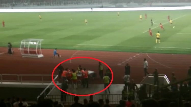 Seorang terduga suporter Malaysia harus ditandu oleh medis usai jadi korban kericuhan di dalam stadion pada laga Timnas Indonesia vs Malaysia, Kamis (05/09/19). Copyright: © Zainal Hasan/INDOSPORT