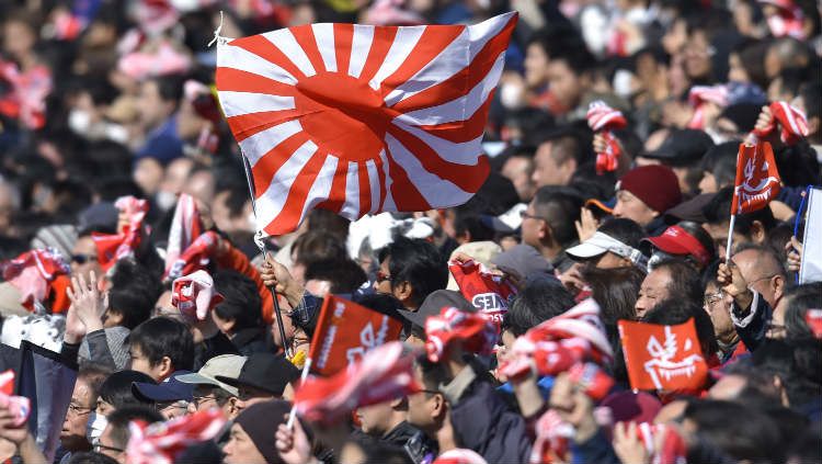 Bendera Jepang 'Rising Sun' yang dikibarkan suporter dalam sebuah pertandingan rugby di Jepang. Copyright: © Koki Nagahama/Getty Images