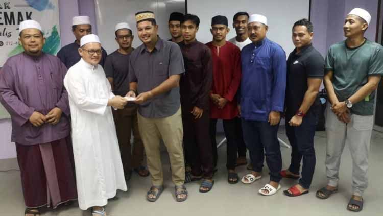 Aidil Sharin memberikan santunan kepada pelajar tahfiz Intitut Al Quran Darul Aman (IQDAR) di Kedah. Copyright: © beritaharian.sg