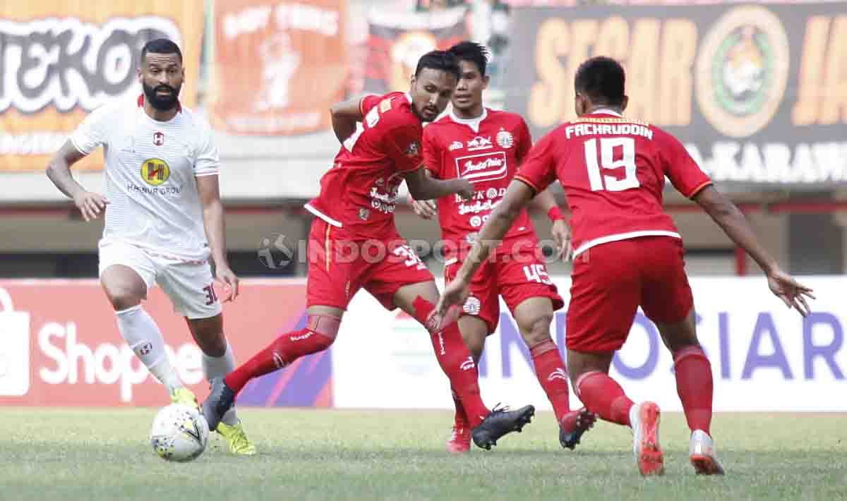 Walian berusaha keras untuk merebut bola dari ketiga pemain Persija Jakarta. Copyright: © Herry Ibrahim/INDOSPORT