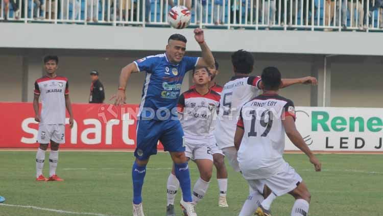 Cristian Gonzales mengambil bola atas dari pemain Madura FC. Copyright: © Ronald Seger Prabowo/INDOSPORT