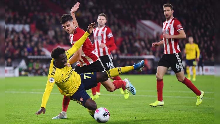 Bukayo Saka dijatuhkan pemain lawan pada laga Sheffield United vs Arsenal di Liga Inggris (Premier League) 2019/2020, Selasa (22/10/19). Copyright: © Twitter/@OptaJoe