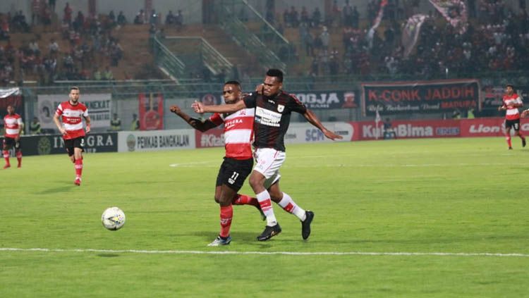 Greg Nwokolo berduel dengan pemain lawan pada laga Madura United vs Persipura Jayapura di Liga 1 2019, Minggu (03/11/19). Copyright: © Media Officer Madura United