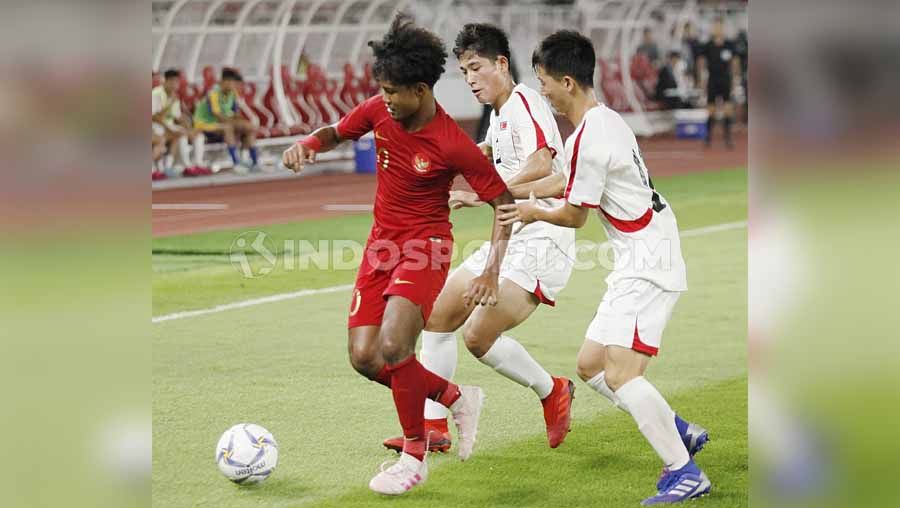 Pemain Timnas Indonesia U-19 Bagus Kahfi berusaha menghindar dari pemain Korea Utara U-19 pada Kualifikasi Piala Asia U-19 di GBK Jakarta, Minggu (10/11/19). Copyright: © Herry Ibrahim/INDOSPORT