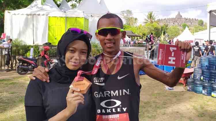 Agus Prayogo, pelari yang finis pertama di Boronudur Marathon bersama istri. Copyright: © INDOSPORT/Arif Budi Setyanto