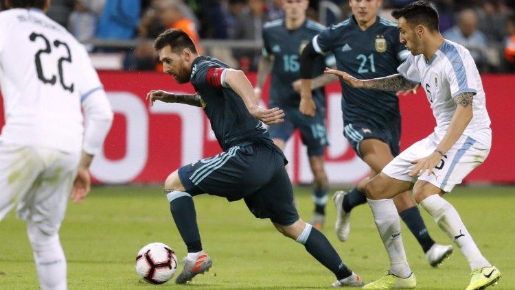 Lionel Messi saat dijaga oleh bek lawan dalam pertandingan persahabatan Argentina vs Uruguay, Selasa (19/11/19) dini hari WIB. Copyright: © afa.com.ar