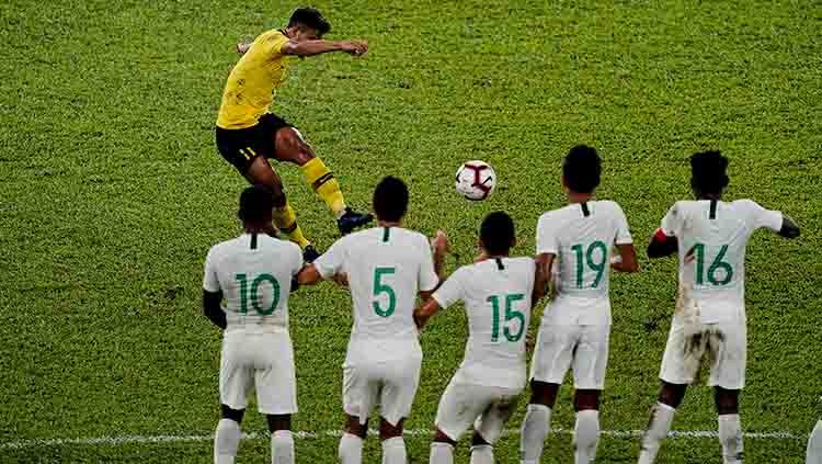Striker Malaysia, Muhammad Safawi Rasid, melakukan tendangan bebas ke gawang timnas Indonesia Copyright: © Allsport Co./Getty Images