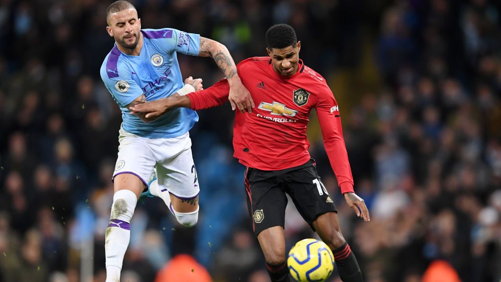 Kyle Walker saat berduel dengan Marcus Rahsford di laga Manchester City vs Manchester United Copyright: © Laurence Griffiths/Getty Images